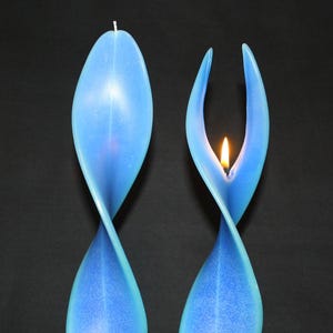 Könnte beinhalten: Zwei blaue Spiralkerzen, eine davon brennt, mit einer Flamme in der Mitte der Kerze.