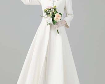 May include: A white coat with a flared skirt, worn with lace gloves and a bouquet of flowers. The coat has a classic design with a rounded collar and long sleeves. The model is wearing white heels.