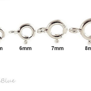 Könnte beinhalten: Vier silberne Sprungringe mit Federschlössern, mit einem Durchmesser von 5 mm, 6 mm, 7 mm und 8 mm.