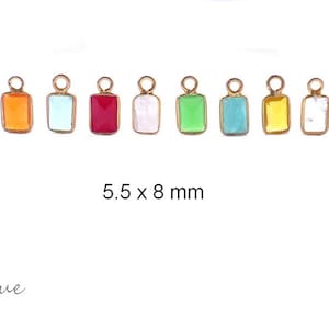 Puede incluir: Diez pequeños amuletos rectangulares de vidrio con lazos de metal dorado. Los amuletos son de varios colores, incluyendo turquesa, naranja, azul claro, rojo, blanco, verde y amarillo. Los amuletos miden 5,5 x 8 mm.