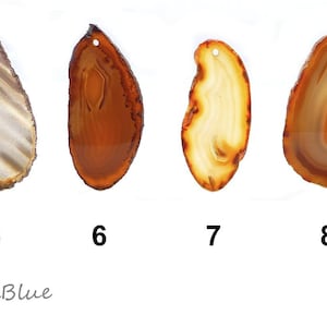 Könnte beinhalten: Vier Agatscheiben in Braun-, Beige- und Cremetönen, jede mit einem einzigartigen Muster und Form. Die Scheiben sind mit 5, 6, 7 und 8 nummeriert. Jede Scheibe hat ein kleines Loch oben.