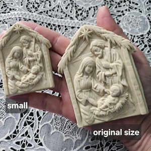 Peut inclure: Deux sculptures en relief de couleur crème représentant une scène de nativité avec une étoile au sommet. Une pièce est étiquetée small et l'autre original size. Les sculptures présentent les figures de Marie, Joseph et l'enfant Jésus.