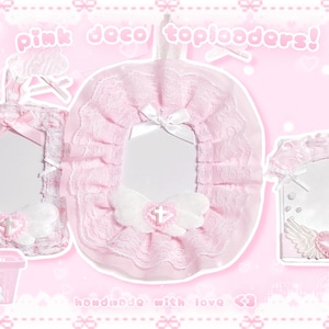 May include: Pink deco toploaders with lace trim, bows, and heart accents. The image shows three different toploader designs, including a basket, all with a cute, feminine aesthetic. The text "handmade with love <3" is also visible.