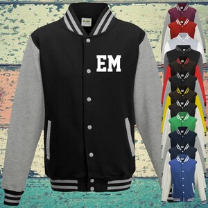 May include: A black varsity jacket with grey sleeves, a striped collar, cuffs, and hem. The jacket features a front button closure, two side pockets, and the white letters EM printed on the chest. A vertical column of similar jackets in various colours.