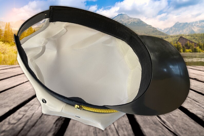 May include: White and black captain's hat with a gold trim. The hat is turned inside out, showing the black lining.