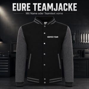 Op de afbeelding: Een zwart en antracietgrijs varsity-jack met een drukknoopsluiting aan de voorzijde, een gestreepte geribbelde kraag, boorden en zoom. Op de borst staat de witte tekst SERVICE TEAM. De tekst bovenaan luidt EURE TEAMJACKE Mit Name oder Teamtext vorne.