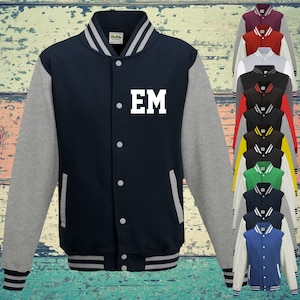 May include: A navy blue varsity jacket with heather grey sleeves, featuring the white letters EM on the left chest. The jacket has a snap-button front, striped ribbed collar, cuffs, and hem, and is displayed alongside a column of various colour options.