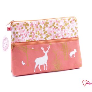 Könnte beinhalten: Eine rosa Tasche mit doppeltem Reißverschluss und einem weißen Hirsch-, Hasen- und Fuchsdesign. Die Tasche hat ein rosa-goldenes Konfetti-Muster auf der oberen Hälfte.