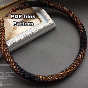 May include: A beaded necklace in black and bronze colors. The necklace is circular, with a pattern of bronze chevrons on a black background. The clasp and end pieces are bronze-colored metal. The image also includes the text "PDF files Pattern" and "Kaira Bijou".