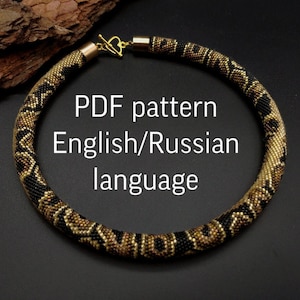 May include: A beaded necklace with a gold clasp and a pattern of black, brown, and gold beads. The text "PDF pattern English/Russian language" is displayed in white letters.