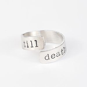 May include: A silver ring with the words "till death" engraved on it.
