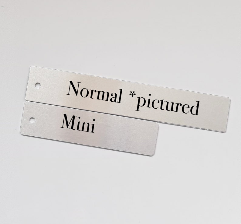 May include: Two silver metal tags with black text. The top tag reads "Normal * pictured". The bottom tag reads "Mini".