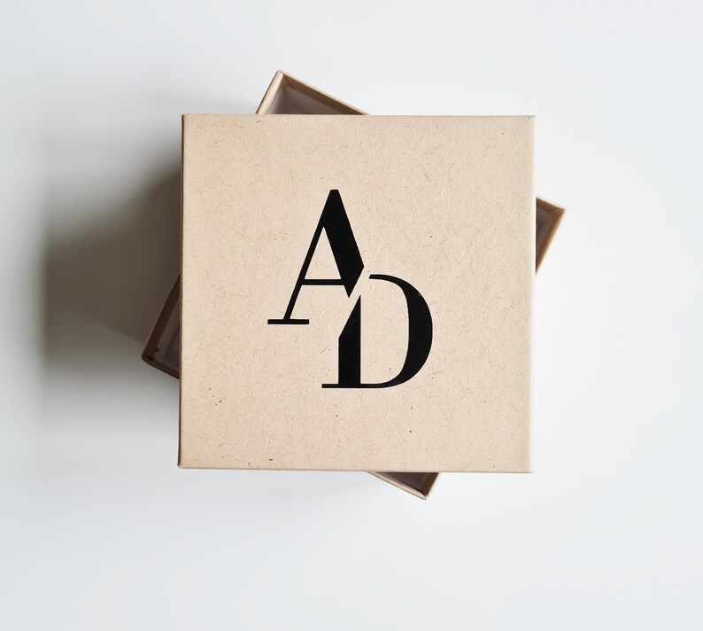 May include: A brown cardboard box with the letters "AD" printed in black on the top.