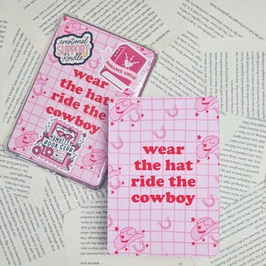 May include: Pink and white printable with a grid pattern and pink cowboy hats and horseshoes. The text "wear the hat ride the cowboy" is in red.