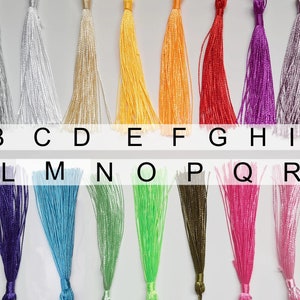 May include: A chart of 19 different colored tassels, labeled with letters A through S. The tassels are arranged in two rows, with the first row labeled A through J and the second row labeled K through S.