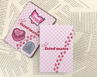Puede incluir: Una funda de teléfono a cuadros rosa y blancos con un corazón rosa, una lápida y un diseño de huellas de patas. La funda tiene el texto "Team whoever the villain" y "fated mates".
