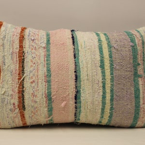 May include: Rectangular woven cushion with a striped pattern. The cushion features vertical stripes in shades of pink, green, purple, and orange. The fabric has a textured, slightly distressed appearance, suggesting a handmade or vintage origin.