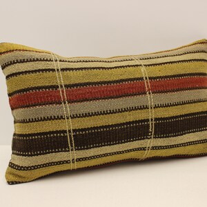 May include: A striped throw pillow with brown, yellow, and red stripes. The pillow is made of woven fabric and has a rectangular shape.