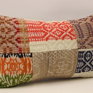 May include: A rectangular patchwork pillow with a variety of colors and patterns, including red, orange, green, blue, and brown. The pillow is made of a soft, woven fabric and has a subtle sheen.