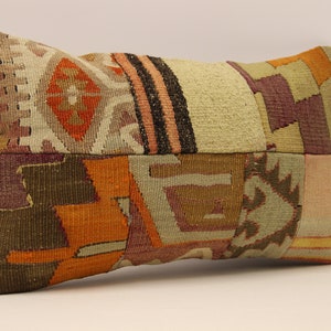 May include: A rectangular patchwork pillow with a variety of colors and patterns, including orange, brown, green, and purple.