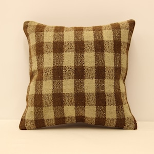 May include: A brown and beige checkered throw pillow with a square shape.