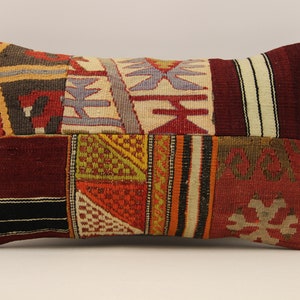 Könnte beinhalten: Ein rechteckiges Kissen mit Patchwork-Muster. Das Kissen besteht aus verschiedenen Stoffen mit verschiedenen Farben und Mustern, darunter Rot, Orange, Gelb, Grün, Blau und Schwarz.
