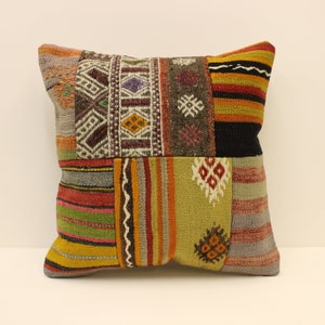May include: A colourful patchwork cushion featuring a range of geometric patterns in shades of red, orange, yellow, green, blue, and brown.