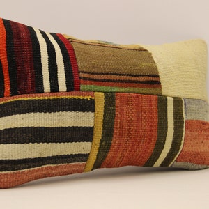 May include: A rectangular patchwork pillow with a variety of colorful stripes in shades of red, orange, yellow, green, blue, black, and white.