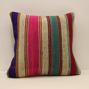May include: A striped throw pillow with a cream background and colorful stripes in shades of pink, blue, orange, and purple.