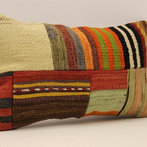 May include: A rectangular patchwork cushion with a variety of colours and patterns, including red, orange, yellow, green, blue, and black. The cushion is made of woven fabric and has a slightly textured surface.