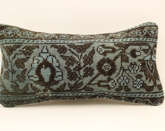 May include: A rectangular pillow with a blue and brown floral pattern. The pillow is made from a woven fabric and has a fringed edge.