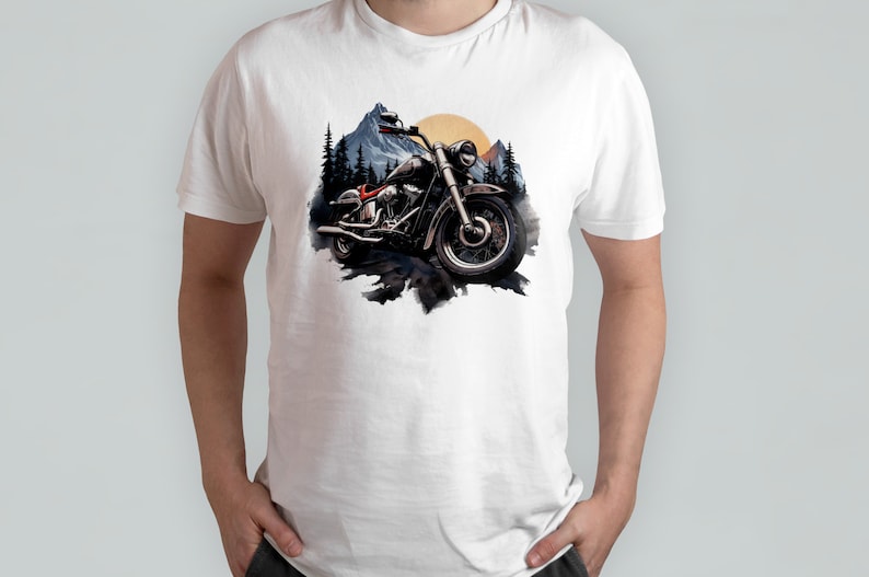 May include: A white t-shirt featuring a graphic of a black motorcycle in front of a mountain range with a sunset in the background.