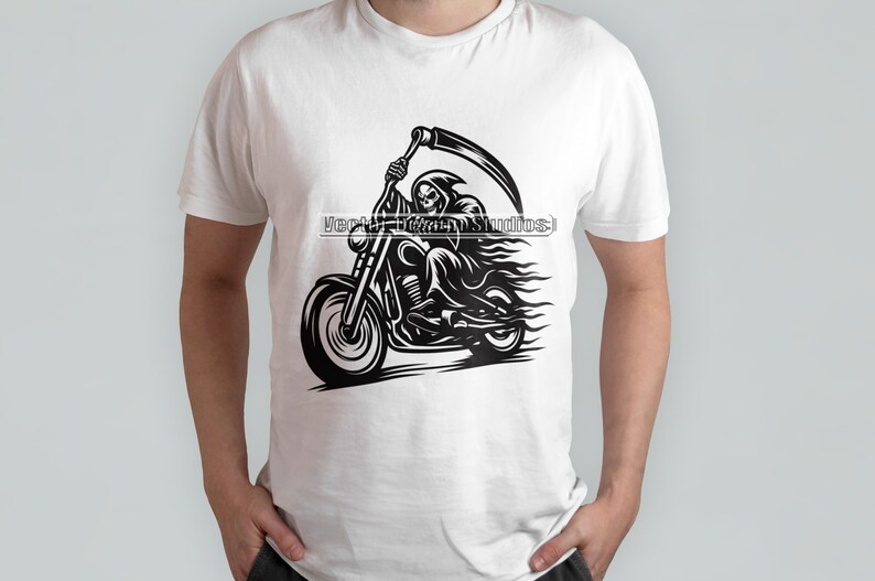 Może przedstawiać: Biała koszulka z czarną grafiką przedstawiającą Grim Reapera na motocyklu, trzymającego kosę. Projekt zawiera płomienie i tekst "Vector Team Studios".