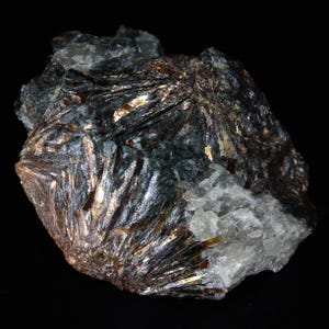 May include: A cluster of dark gray and silver metallic crystals with a rough, textured surface. The crystals have a sharp, angular shape and are arranged in a radial pattern.