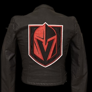 May include: Black leather jacket with a red and white embroidered patch of a knight's helmet on the back.