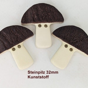 Könnte beinhalten: Drei pilzförmige Dekorationsgegenstände. Jeder Pilz hat einen dunkelbraunen, strukturierten Hut und einen cremefarbenen Stiel. Der Text "Steinpliz 32mm Kunststoff" ist unten im Bild zu sehen.