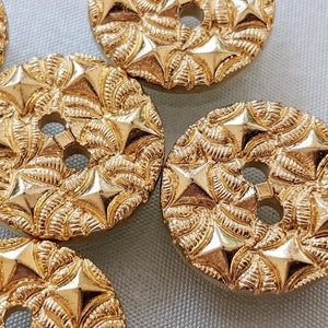 May include: Gold-colored buttons with a starburst design and a two-hole center.