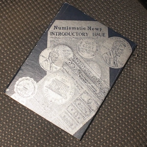 May include: A black and white magazine cover with the title "Numismatic News INTRODUCTORY ISSUE". The cover features several images of coins and a portrait of a person.