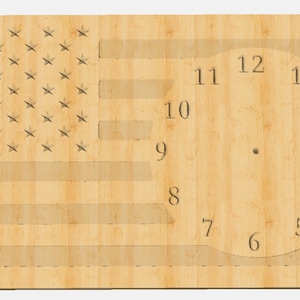 Puede incluir: Cara de reloj de madera con diseño de bandera estadounidense. La esfera del reloj tiene números romanos para las horas del 1 al 12.