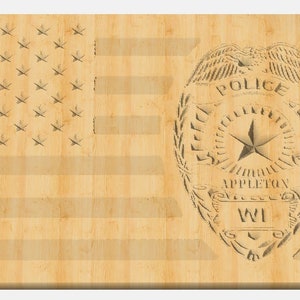 May include: A wooden American flag with a police badge superimposed on it. The badge has the words "Police", "Appleton", and "WI" on it.
