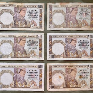 Puede incluir: Seis billetes serbios de 500 dinares. Cada billete presenta un retrato de una mujer con pañuelo y el texto "СРПСКА НАРОДНА БАНКА" y "ПЕТ СТОТИНА ДИНАРА". Los billetes son en tonos marrones, morados y beige.