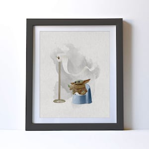 May include: A framed watercolor illustration of a small, green, fictional character sitting on a blue potty with a roll of toilet paper hanging in the background.
