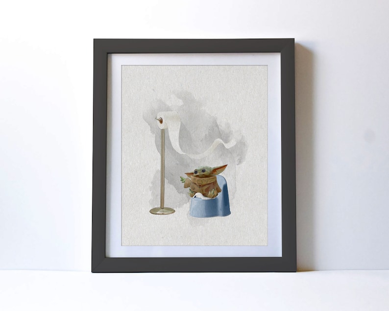 May include: A framed watercolor illustration of a small, green, fictional character sitting on a blue potty with a roll of toilet paper hanging in the background.