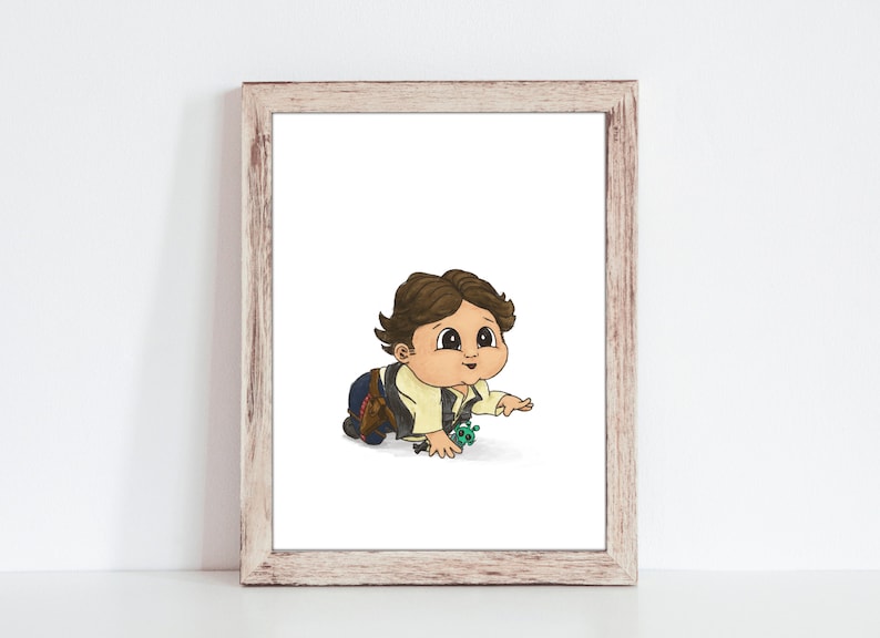 May include: A framed print featuring a cartoon illustration of a baby crawling. The baby has brown hair, a tan shirt, and a dark vest. The artwork is in a wooden frame and is set against a white background.