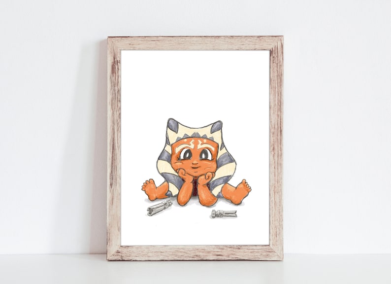 May include: A framed print featuring a cartoon illustration of a character with orange skin, a headpiece, and blue and white markings. The character is sitting with hands under the chin, with two silver objects in front.