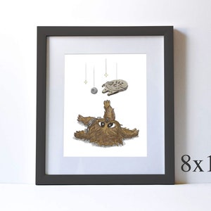 May include: A framed illustration of a brown and white Wookiee character from Star Wars lying on its back with its arms and legs outstretched. The character is looking up at a small, gray spaceship hanging from the ceiling. The spaceship is surrounded by three small, yellow stars.