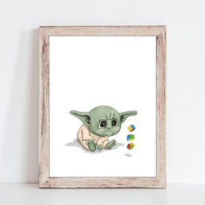 May include: A framed print featuring a watercolor illustration of a baby alien with large eyes and pointed ears. The alien is sitting and looking down, with three colorful toy blocks nearby. The frame is made of light-colored wood.