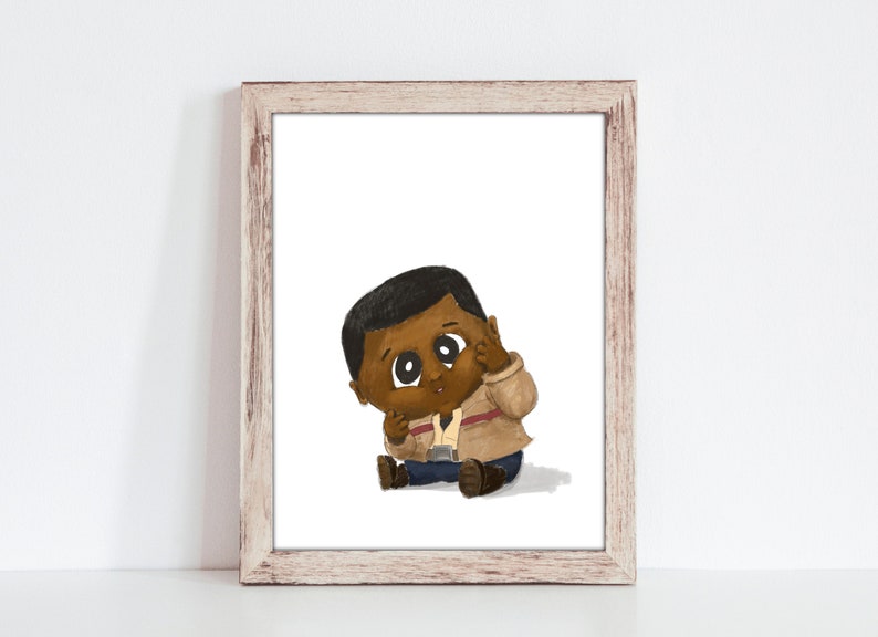 May include: A framed art print featuring a cartoon illustration of a baby with dark skin. The baby is wearing a tan jacket, blue pants, and brown shoes. The baby is sitting down and touching their face. The frame is light brown.