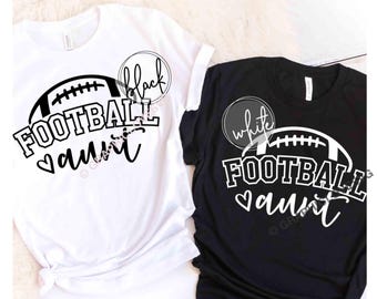 May include: A white t-shirt with a black graphic and a black t-shirt with a white graphic. Both shirts feature a football illustration above the text "FOOTBALL aunt" and a small heart icon. The white shirt has a circle with the text "black" and the black shirt has a circle with the text "white".