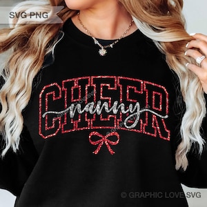 May include: A black long-sleeve sweatshirt featuring the word CHEER in large red glitter block letters with the word nanny written in silver glitter script across the center. A small red glitter bow is positioned below the text.